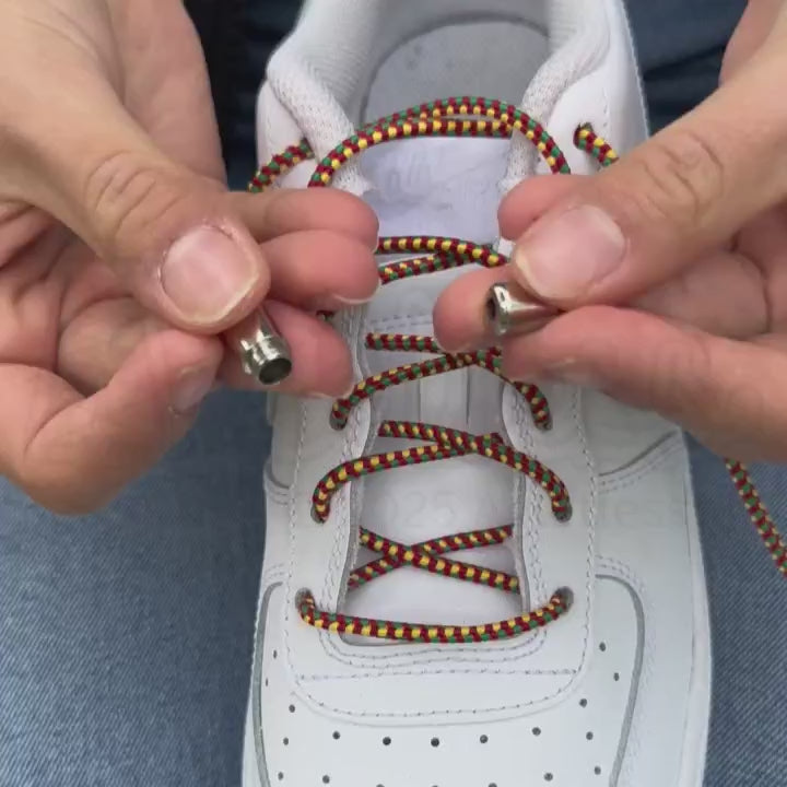 Instructievideo waarin wordt getoond hoe driehoekige elastische veters van 3 mm in rood, geel en groen met een capsule-sluiting worden geïnstalleerd, inclusief aandacht voor juiste spanning en afwerking