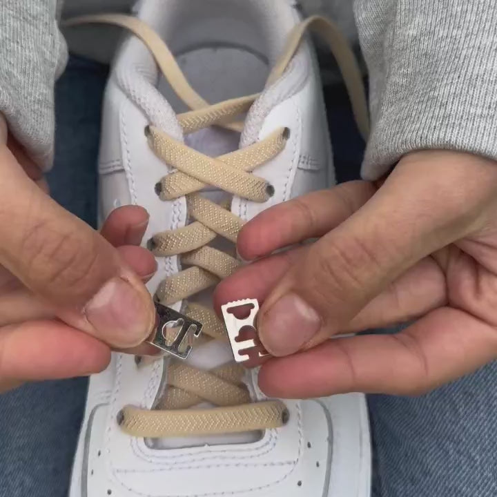 Stap-voor-stap uitlegvideo waarin wordt getoond hoe beige platte elastische veters van 8 mm met clipjes worden geïnstalleerd en netjes worden afgewerkt